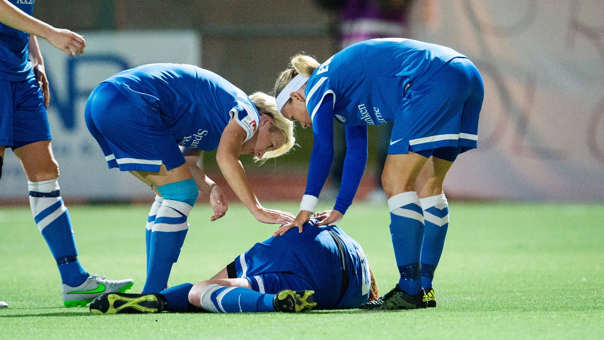 En fotbollsspelare tittas till av lagkamrater efter en kollision i damallsvenskan 2015. Arkivbild.