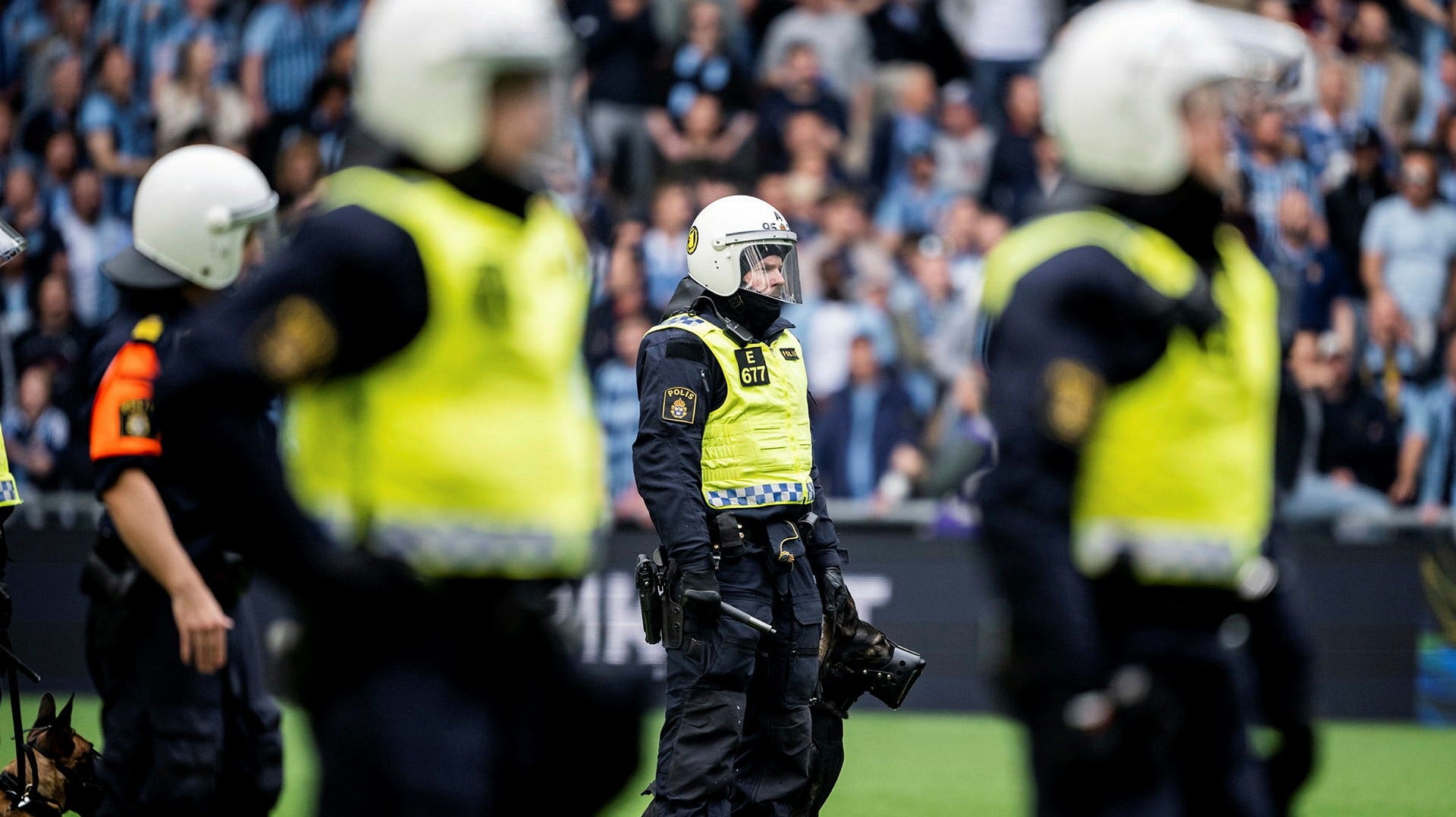 Kravallpoliser med hundar tvingades inta planen på Tele2 arena på söndagen sedan AIK-supportrar börjat kasta knallskott och bengaler.
