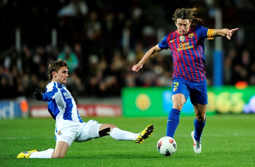 Antoine Griezmann, who by then had established himself as a key Real Sociedad player, in a duel with FC Barcelona central defender Carles Puyol in February 2012.