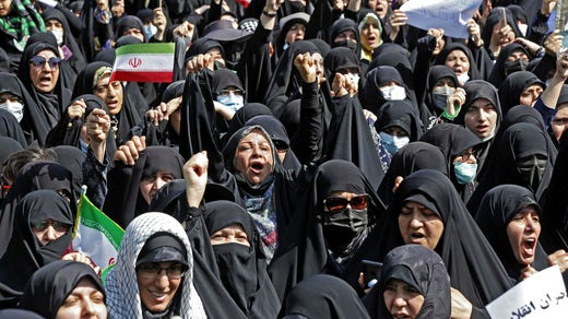 Motdemonstranter stöder kravet på att bära hijab.