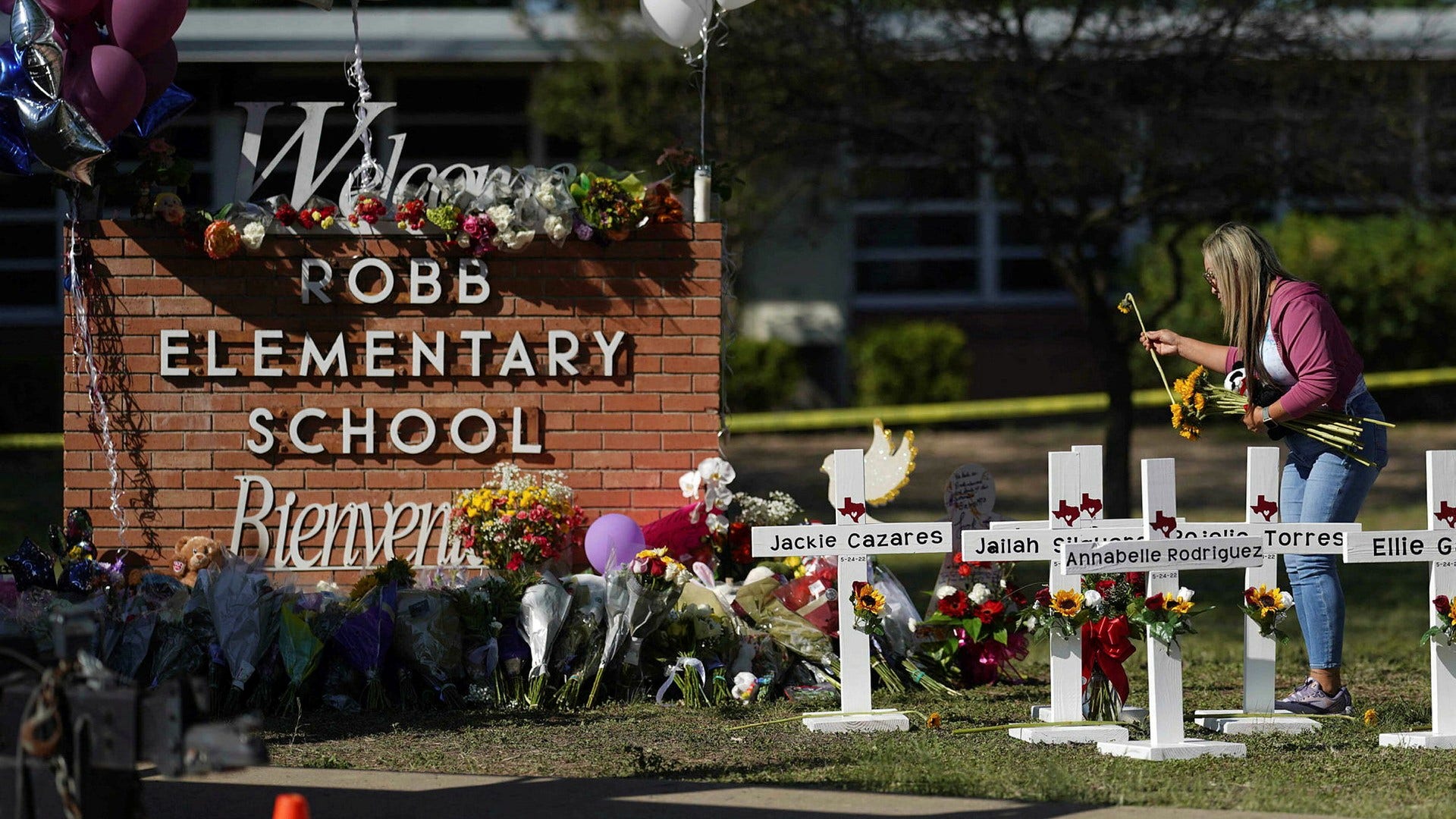 Människor lämnar blommor vid Robb Elementary School i Uvalde.