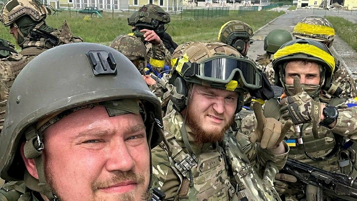 Den här bilden sägs föreställa medlemmar i så kallade Ryska frivilligkåren i Kozinka som ligger i Ryssland, precis intill gränsen till Ukraina. Soldaterna bär gul tejp, vilket är ukrainska arméns sätt att känna igen sina egna. Ukraina säger sig inte ha något med den här operationen att göra – som enligt uppgift ska ha korsat gränsen till Ryssland från just Ukraina.