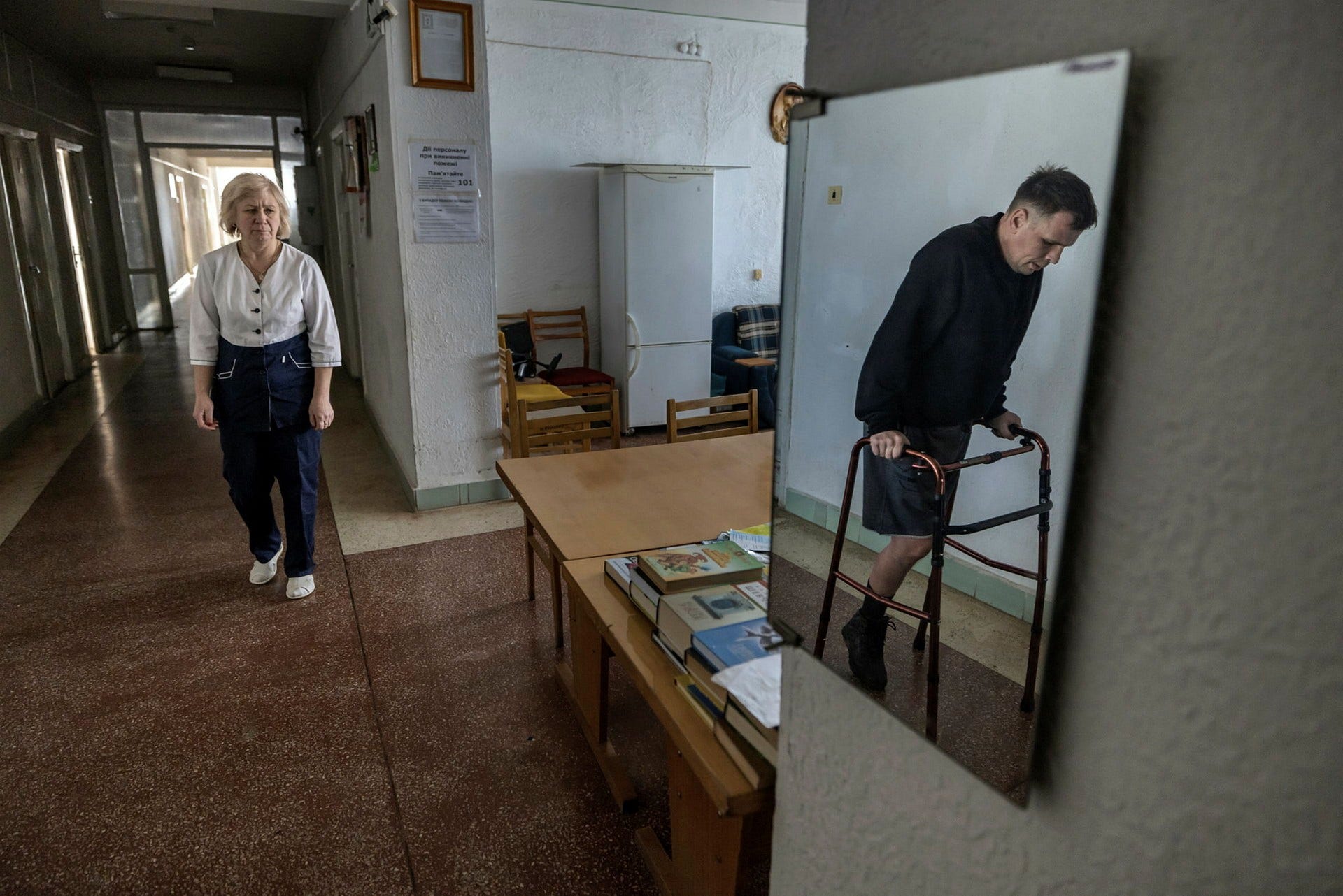 Vadym, 38 år gammal, miste ena benet när ett ryskt flygplan släppte en bomb i Kievregionen. Tillsammans med sjuksköterskan Svitlana genomför han ett av dagens terapipass i korridoren.