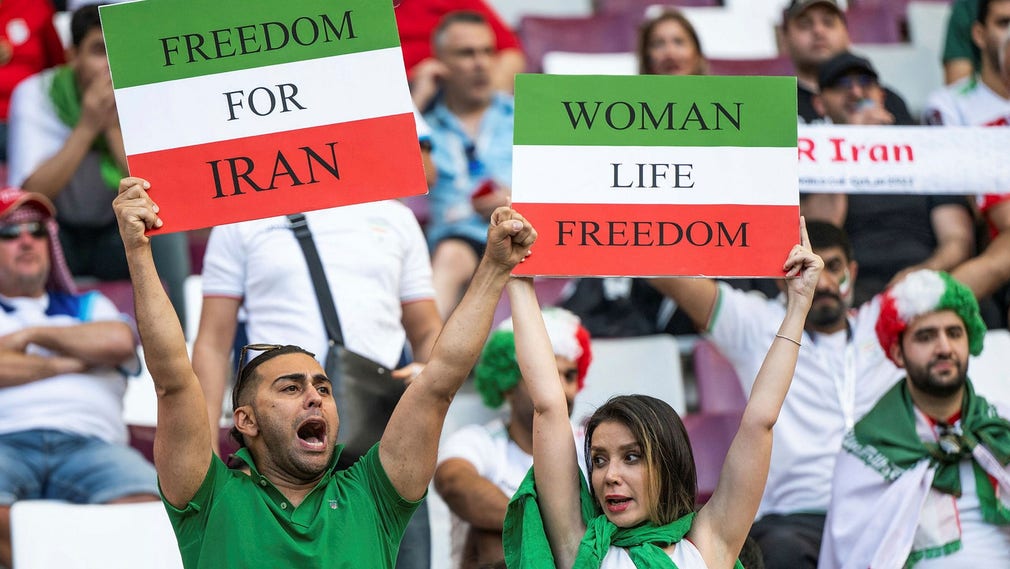 Protester på läktaren under måndagens VM-match mellan England och Iran. Det som från början var ett kvinnligt slöjuppror har nu utvecklats till en revolution, påpekar insändarskribenten.