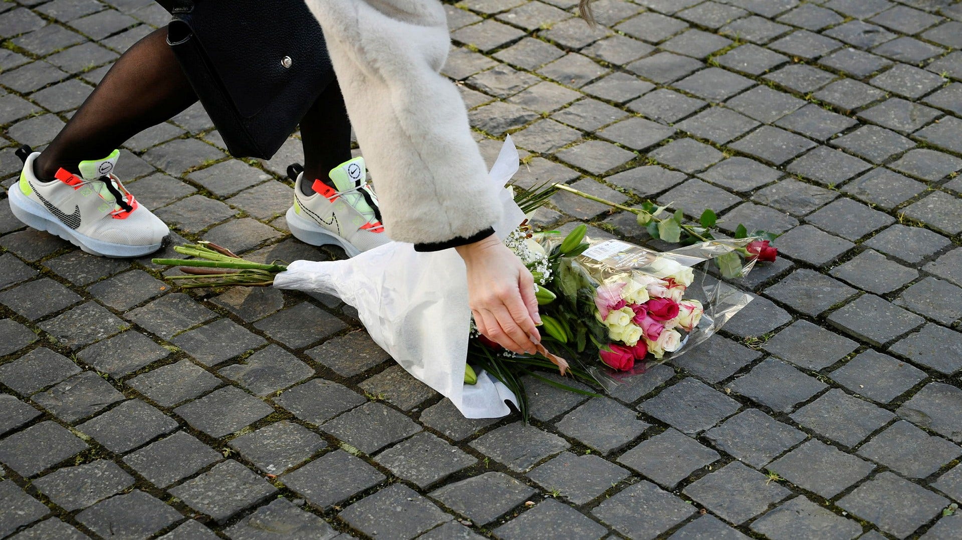 En förbipasserande lämnade på fredagsförmiddagen blommor i anslutning till platsen där artisten Einár sköts till döds.