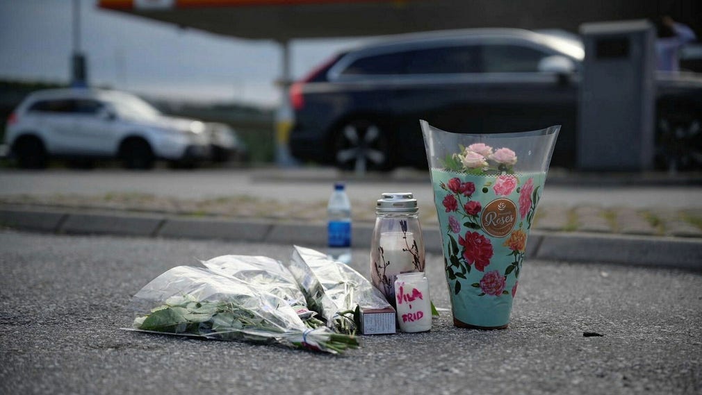 Blommor och ljus vid den snabbmatsrestaurang i Norsborg där den 12-åriga Adriana sköts ihjäl sommaren 2020.