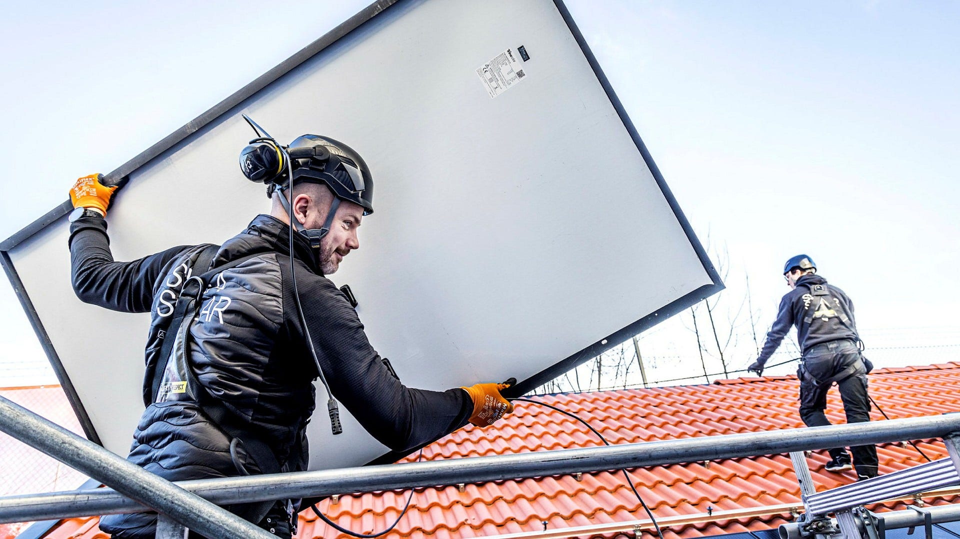 Solpaneler på väg upp på ett villatak. Men den 20-procentiga statliga subventionen på en sådan investering kan minska tillgången på el vintertid, menar skribenten i ett svar på en insändare.