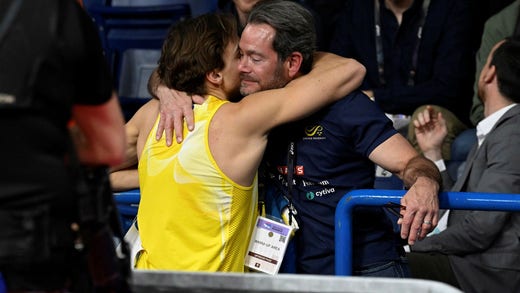 Armand Duplantis och pappa Greg Duplantis kramar om varandra under inomhus-VM i Belgrad.