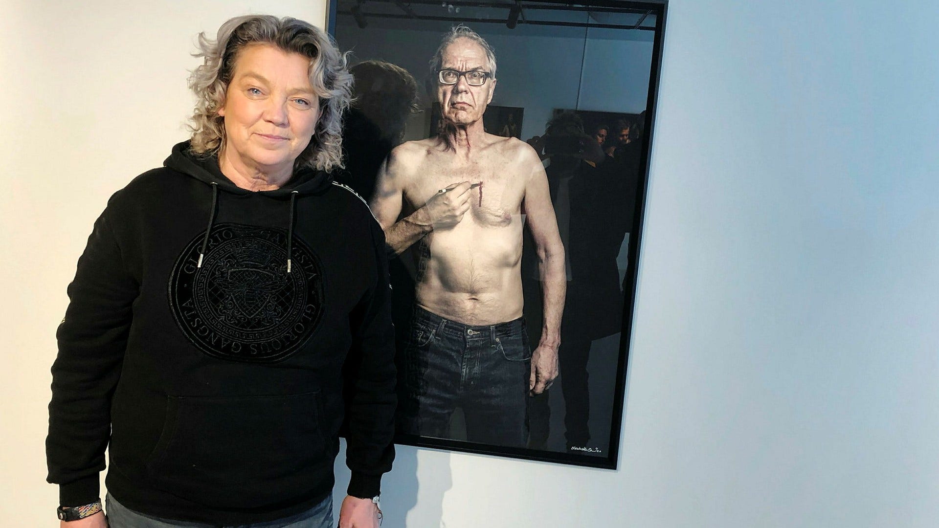 Elisabeth Ohlson och ett porträtt av Lars Vilks.