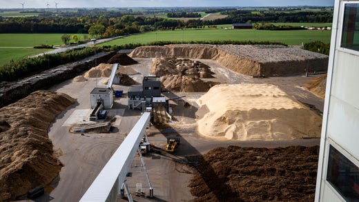 Piles of wood chips and sawdust as well as layers of waste wood at Kraftringen's cogeneration plant in Örtofta.