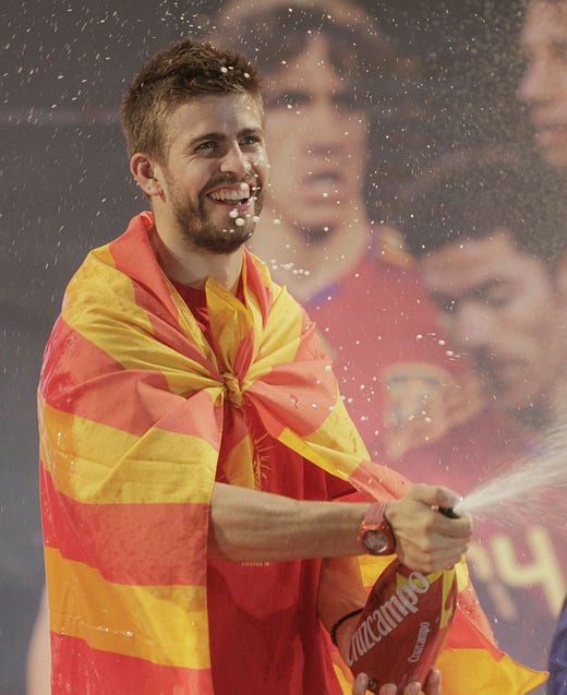 Gerard Piqué firar Spaniens VM-guld 2010 iklädd en ”senyera”, den katalanska flaggan.