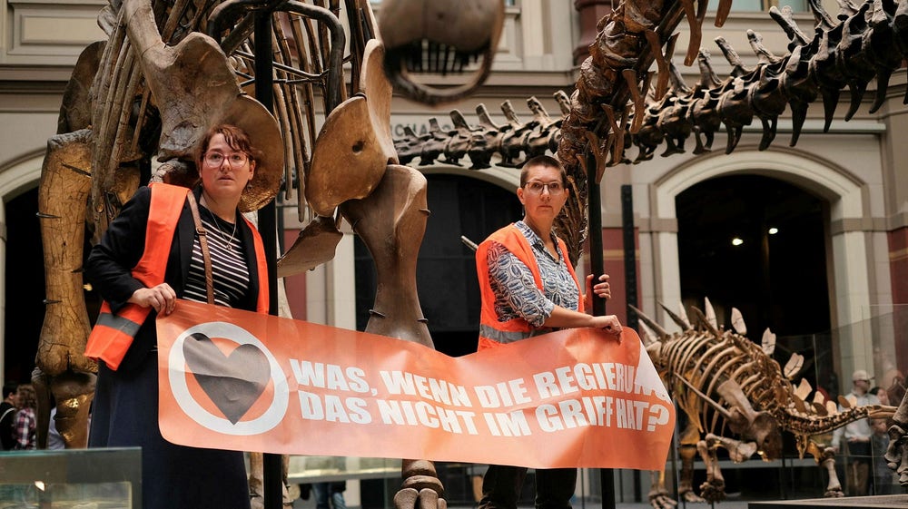 Aktivister klistrade fast sig vid dinosaurie