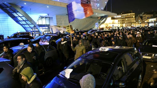 Taxi drivers participate in demonstrations linked to an official strike in 2016. Cutbacks, conditions, and competition by Uber have led to widespread protests and sometimes vandalism of Uber cars.