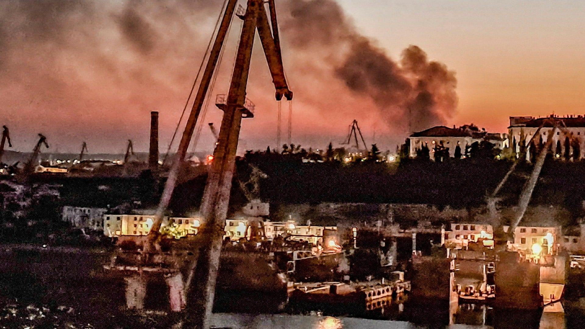 Brandrök stiger mot himlen från hamnen i Sevastopol där en ukrainsk attack skadade två ryska krigsskepp.