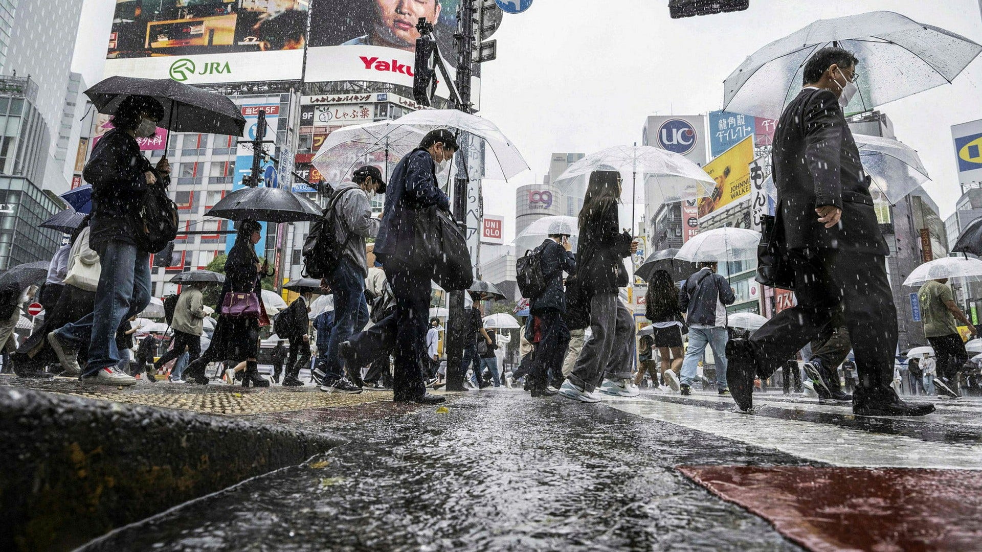 Tokyobor på en regnig gata. Stormen Mawar rör sig mot landet och hundratusentals människor har uppmants att evakuera.