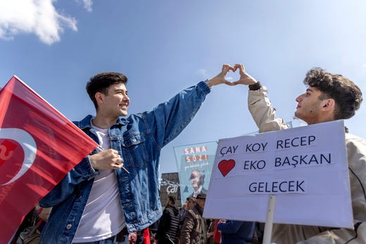 Ulas Bakir and Mehti Tayfun make Kemal Kilicdaroglu's heart gesture with their hands.  Their message to Erdogan is for him to make a cup of tea: 