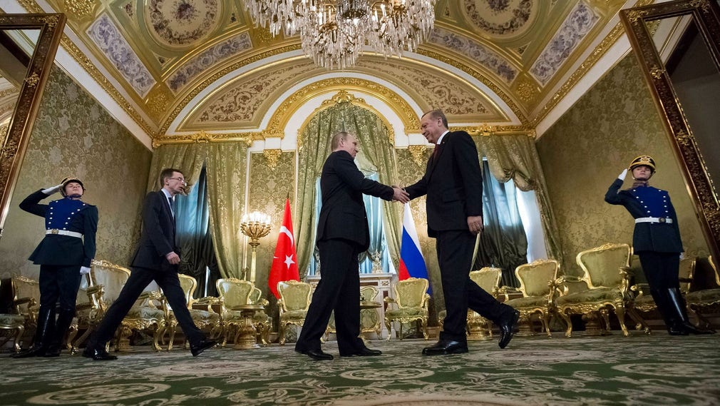 I presidenti Vladimir Putin e Recep Tayyip Erdogan si stringono la mano sugli investimenti congiunti in un vertice a Mosca nel 2017, alla presenza dei proprietari di Rönesans.