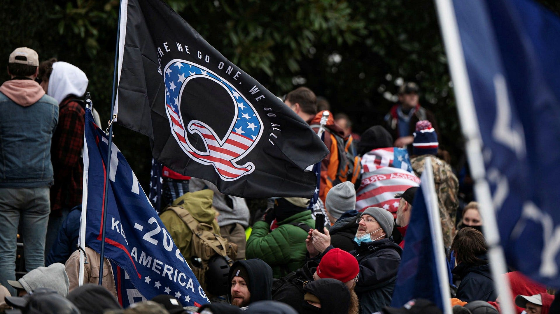 En Qanon-flagga bärs i främsta leden när Trumpanhängare stormade Kapitolium i januari.