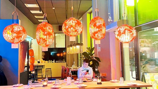 Patterned red rice lamps liven up the otherwise rather bare interior.