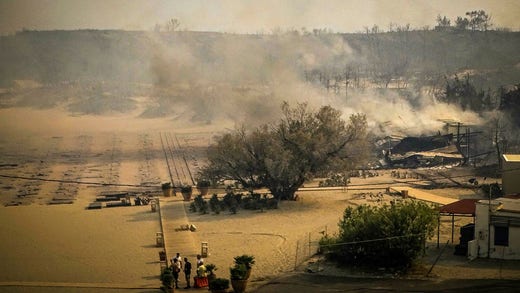 Smoke rises in the village of Kiotari, on the Greek island of Rhodes, as a result of a forest fire in the area.