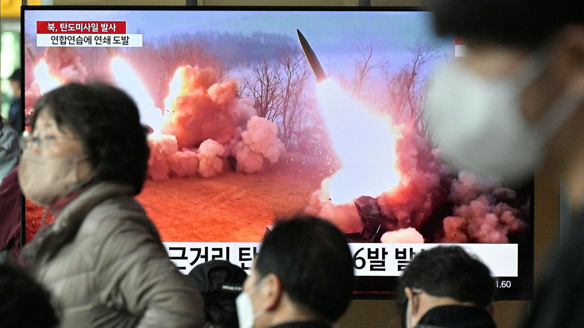 Boende i Seoul passerar en tv-skärm med en nyhetssändning med bilder från en tidigare nordkoreansk uppskjutning.