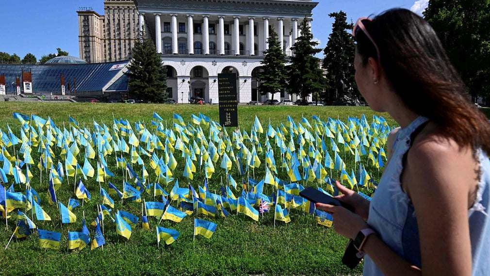 Una donna passa davanti a un monumento alle vittime della guerra a Kiev.
