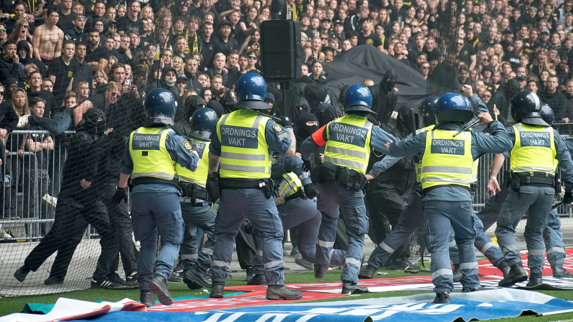 Delar av AIK-klacken försöker storma planen under Stockholmsderbyt mot Djurgården på Tele2 arena i söndags. Flera poliser och vakter samt en polishund skadades.