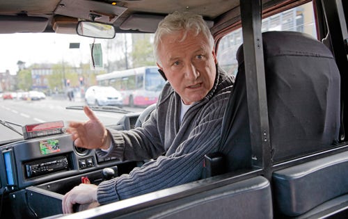 Ken Harper tar med besökarna på en taxirundtur i Belfast...
