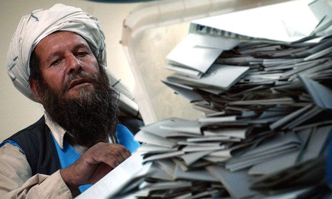 Några år senare, 2004, vinner Karzai presidentvalet med drygt 55 procent av rösterna. Här syns en lokal valarbetare.