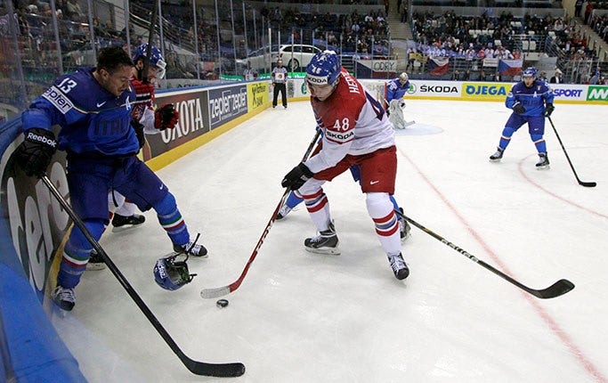 Tjeckiens Tomas Hertl jagar pucken i kamp med Italiens Nathan di Casimiro.