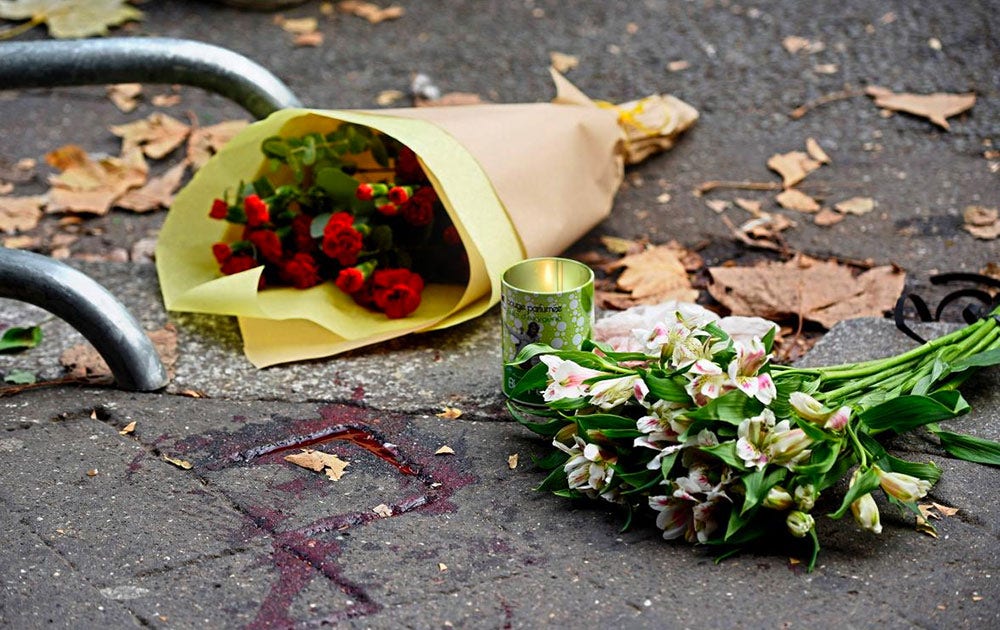 Blommor på den blodiga trottoaren utanför konserthuset Bataclan.