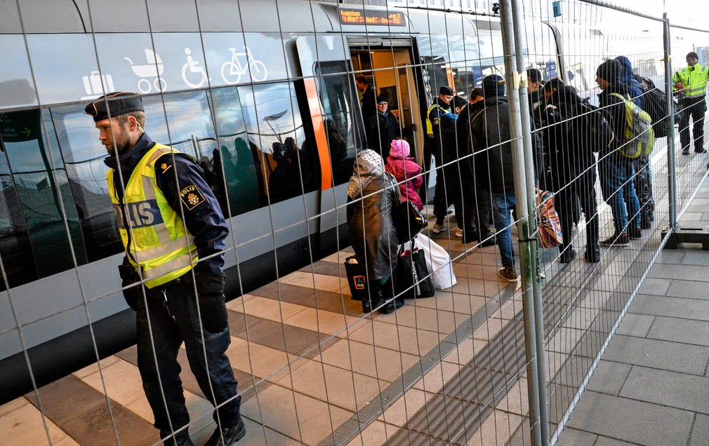 Flyktingar kliver av tåget vid Hyllie station. Ett staktet har satts upp mellan spåren på stationen sedan id-kontrollerna infördes.