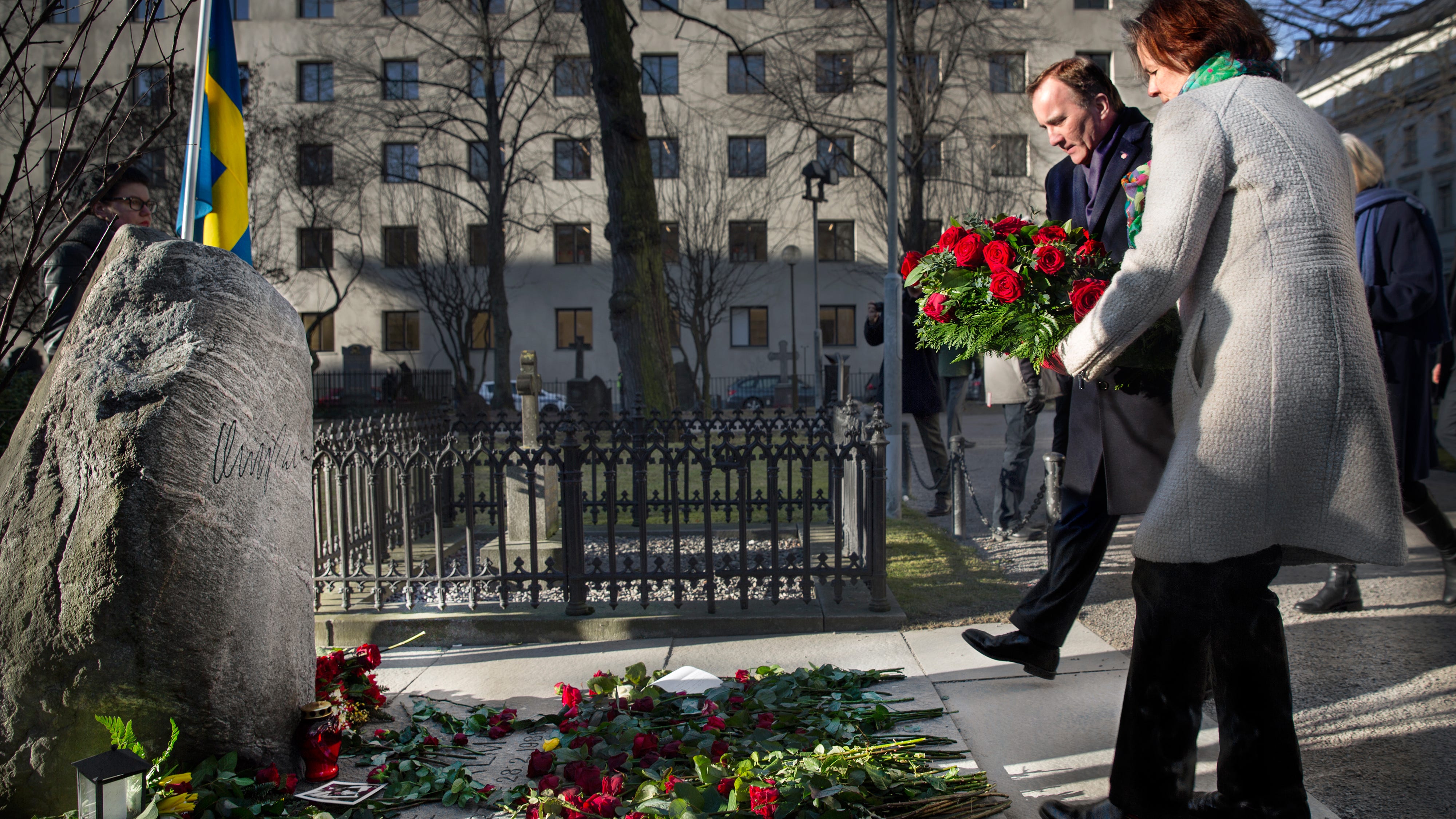 Stefan Löfven och Carin Jämtin lägger blommor på Palmes grav.