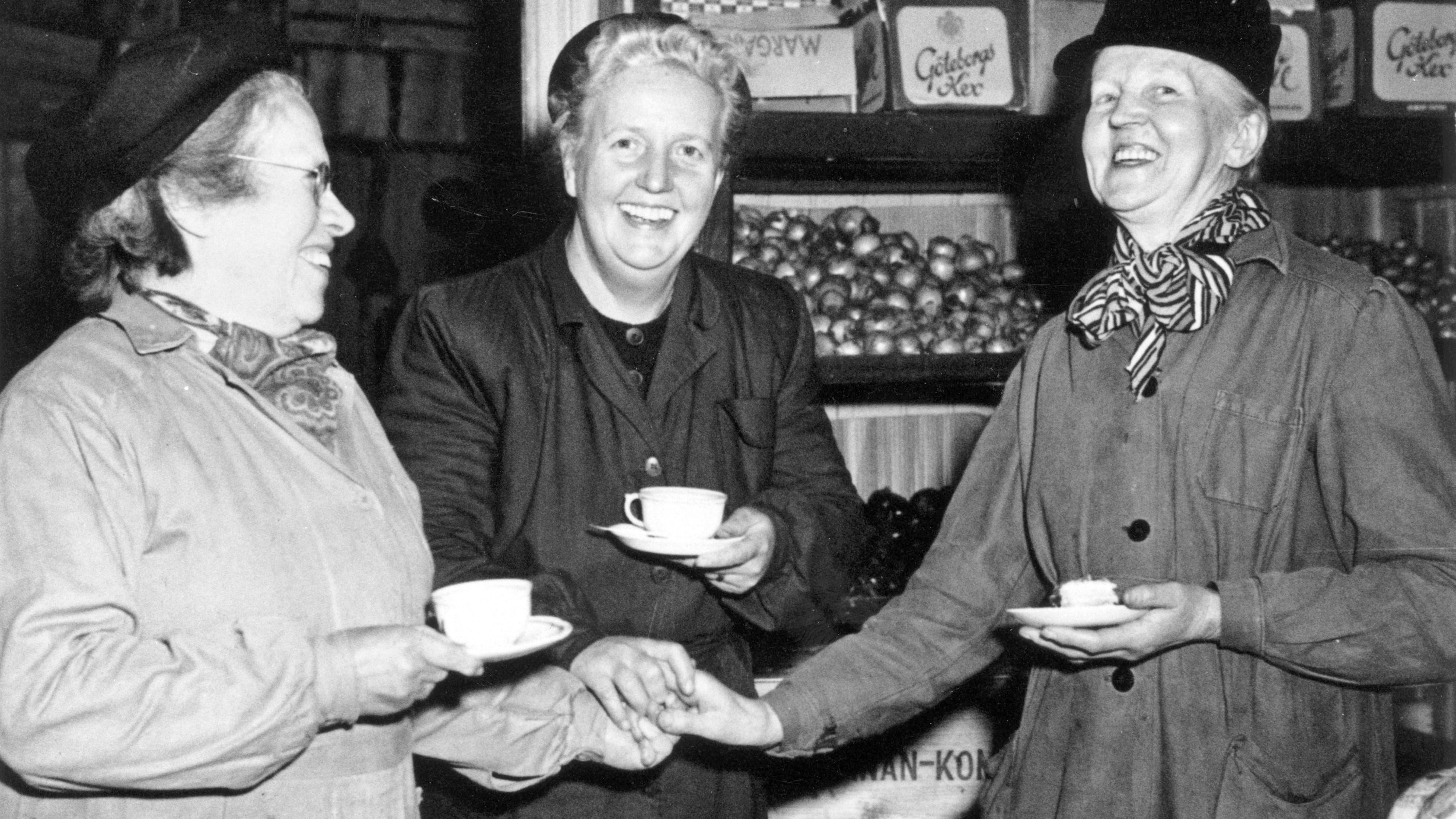 Tre damer på kaffestund år 1952, i grönsaksaffären på Lilla Nygatan i Gamla stan. Bilden är publicerad i boken ”Så roade vi oss”, sidan 84.