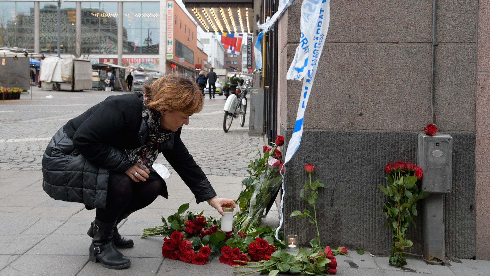 Förra justitieministern Beatrice Ask ställer ner ett ljus i hörnet av Hötorget - Kungsgatan på lördagsmorgonen.