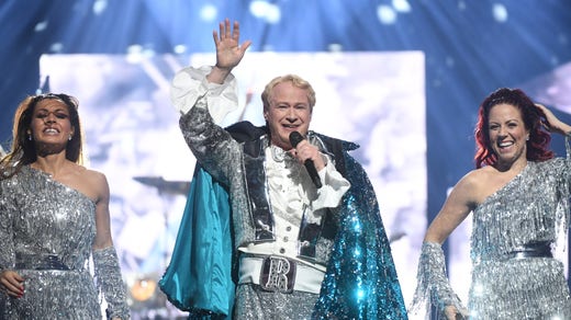 Roland flankerad av körsångarna.