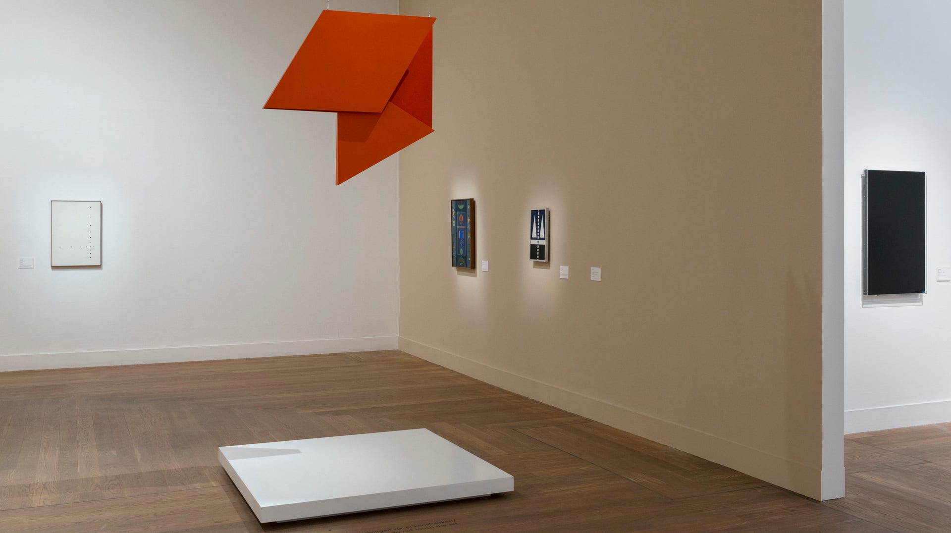 Utställningsvy från ”Conrete matters”, med bland annat Hélio Oiticias rödorange, hängade objekt ur serien ”Revelos espaciales” från 1959.