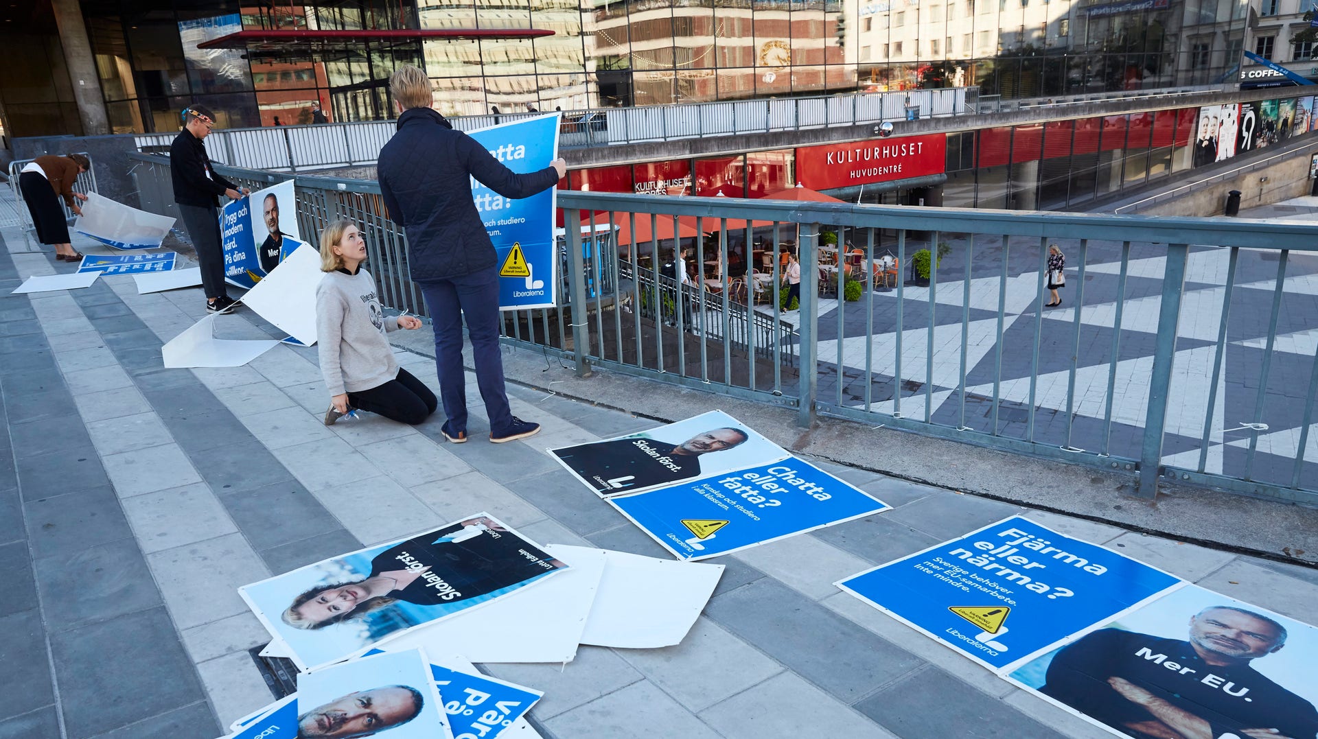Ungdomar arbetar med att sätta tillbaka de valaffischer som rivits ner i centrala Stockholm natten till den 21 augusti.