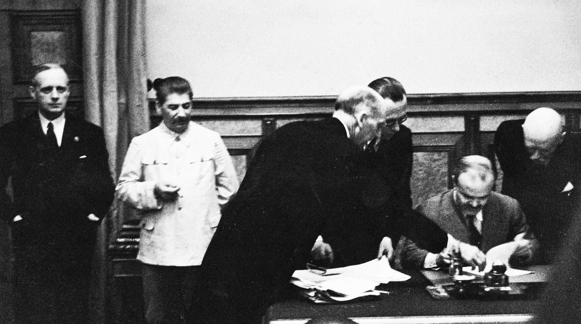 Sovjets utrikesminister Molotov signerar Molotov–Ribbentrop-pakten i Kreml den 23/8 1939. På bilden syns också från vänster den tyske utrikesministern Ribbentrop och Sovjets diktator Josef Stalin.
