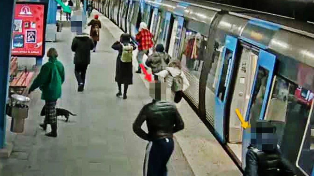 En övervakningskamera fångar hur de två dömda 16-åringarna följer efter sitt rånoffer på en tunnelbanestation i Stockholm.