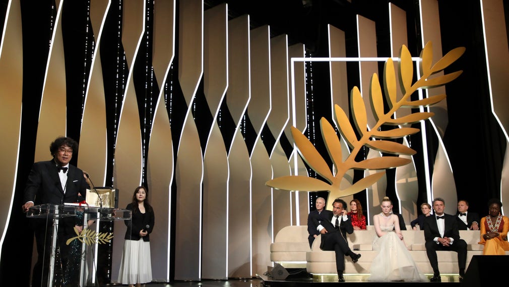 Regissören Bong Joon-ho tar emot Guldpalmen för sin film Parasit i Cannes 2019.