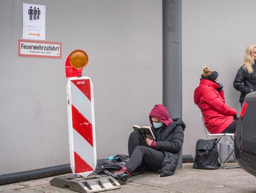 Människor väntar på trottoaren i tyska Frankfurt för att göra coronatest.
