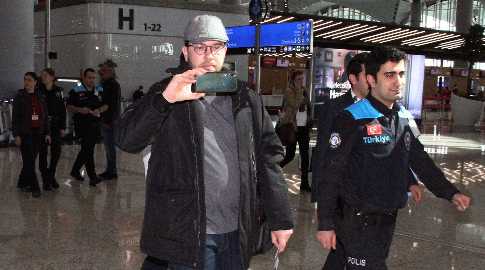 Jimmie Åkesson eskorterad av polis på Istanbuls flygplats.