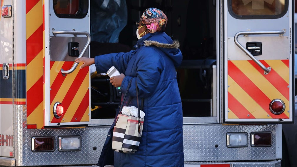 En anhörig följer med en covid-19-smittad person i ambulans till ett sjukhus i New York.