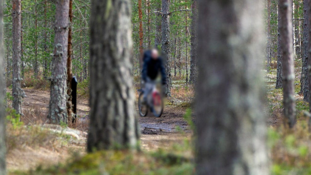 En cyklist försöker ta sig fram obemärkt genom skogen i gränsområdet mellan Norge och Sverige. Coronasmittan har fått grannlandet att skärpa restriktionerna för de som passerar gränsen.