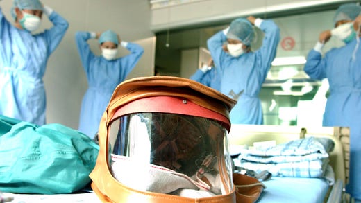 Vårdanställda tar på skyddskläder för att ta hand om patienter sjuka i sars i Guangzhou, april 2003.