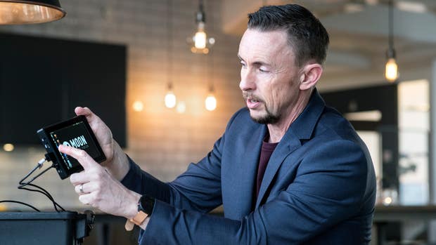 Mathias Farnebo håller i en förproduktionsenhet av Moonlighting Industries smarta avståndsmätare för filmfotografer.