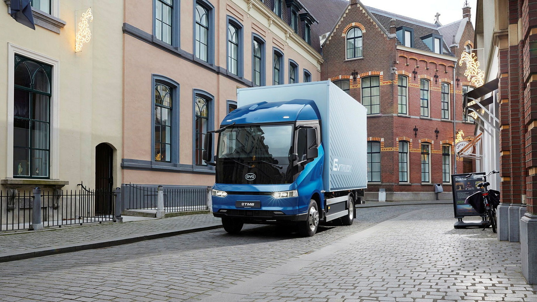 En lastbil av det kinesiska märket BYD kör genom vad som ser ut som en europeisk stad. Märkets dominans oroar västvärlden.