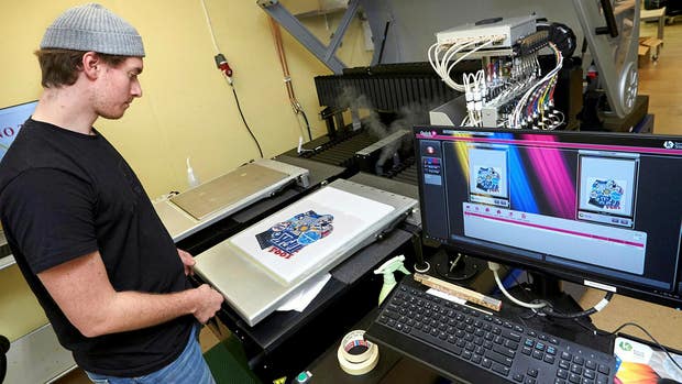 Adam Svenson, tredje generationen i företaget, sköter nyinvesteringen den digital textilprinter.