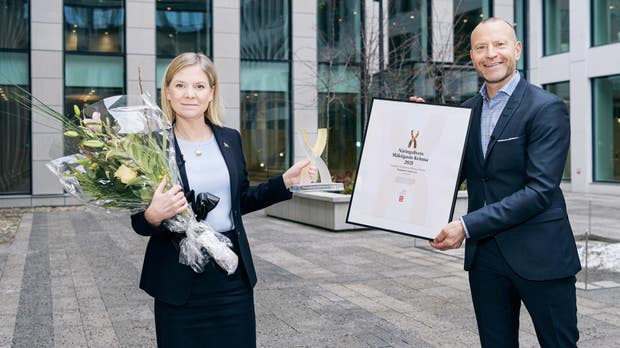 Magdalena Andersson tar emot statyett, blommor och diplom av Dagens industris chefredaktör Peter Fellman.